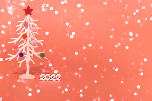 Christmas card. Against the background of Christmas lights, a white Christmas tree in multi-colored fur toys with the numbers 2022. copy space photo