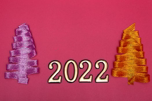 Christmas concept. Purple and gold Christmas tree made of ribbons and gold numbers on a pink background. Template for postcards, packaging. photo