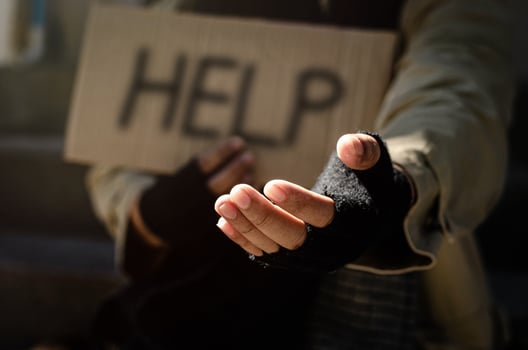 A homeless man begging for help. Ask for a coin of human mercy on a wooden floor in a public walkway. poor homeless people in the city social problems Finance and housing photo