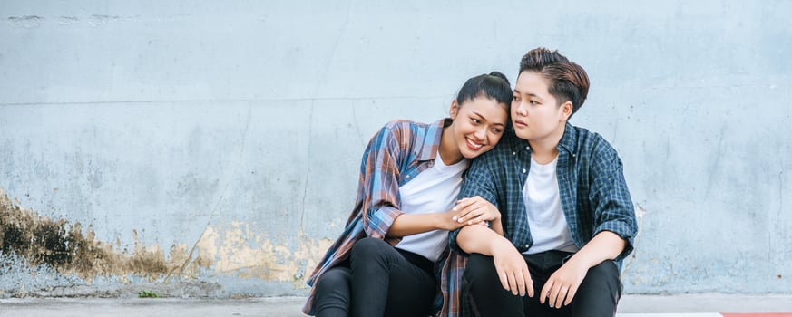 A woman sitting on each other's shoulders by the road. photo