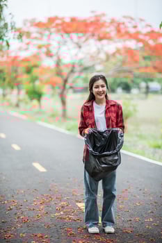 woman collecting garbage in a black bag. photo