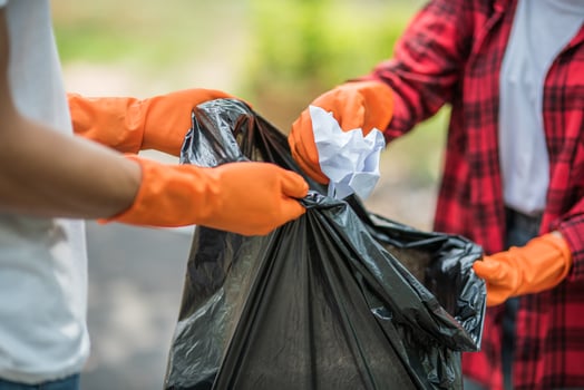 Men and women help each other to collect garbage. photo