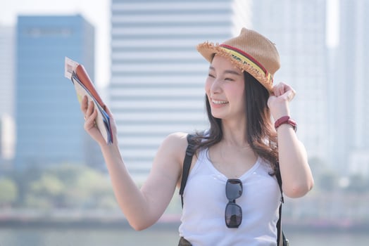 Beautiful asian tourist woman smiling and searching for tourists sightseeing spot. Vacation travel in summer. photo