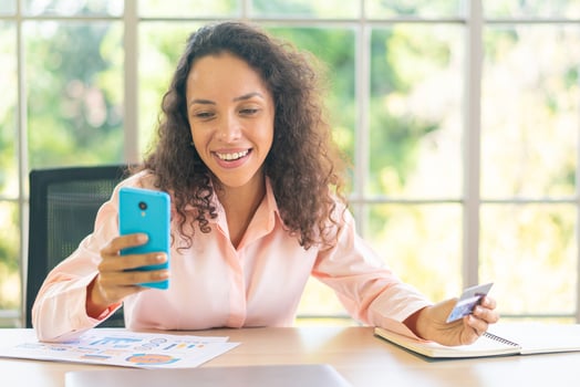 beautiful latin woman using smartphone with credit card photo