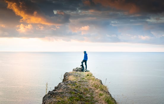 perso with dog on cliff photo