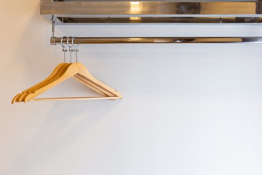 Wooden Three luxury coat hanger on brick wall inside the hotel bedroom interior. photo