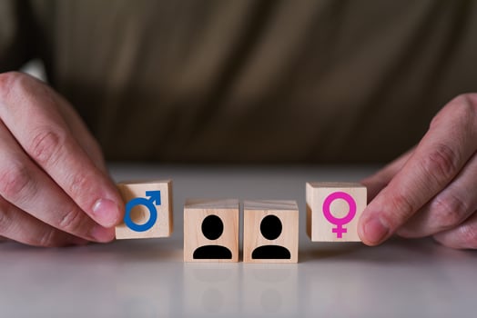 A choice between a man and a woman. the hands point to two wooden cubes with a gender icon, a male and a female sign. photo