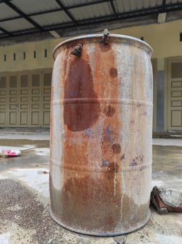 old water barrel that has started to rust in the yard photo
