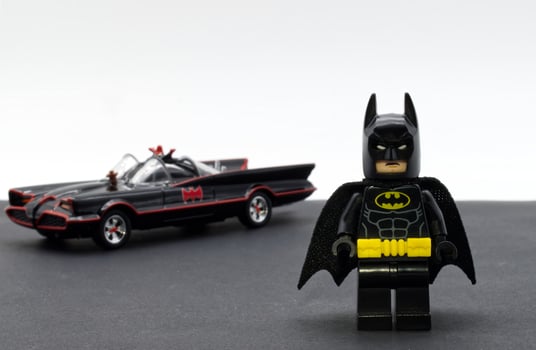 Bologna, Italy, 2021 - Lego Batman miniature with the Batmobile on the background. photo