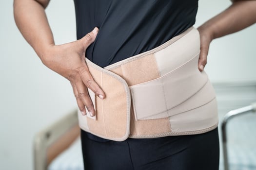 Asian lady patient wearing back pain support belt for orthopedic lumbar with walker. photo