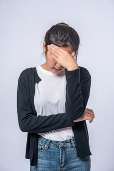 A sick woman with a headache and put her hand on her head photo