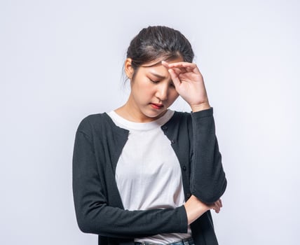 A sick woman with a headache and put her hand on her head photo
