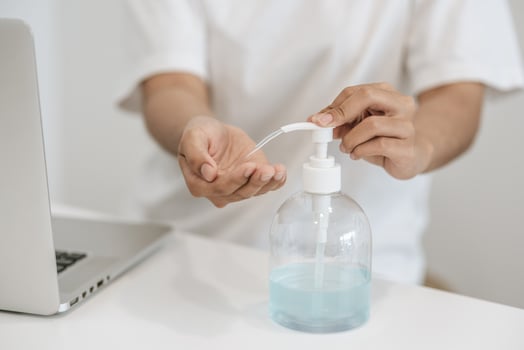Women wearing white shirts that press the gel to wash hands to clean hands. photo
