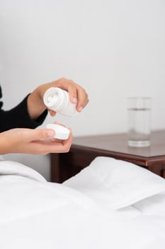A woman who is unwell on the couch and is about to take antibiotics. photo