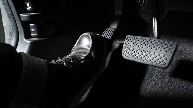 Close up the foot pressing foot pedal of a car to drive ahead. photo