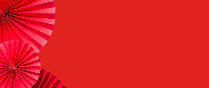 Red paper fans on a red monochrome background copy space. photo