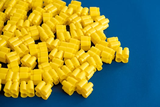 Yellow plastic building blocks on a blue background photo