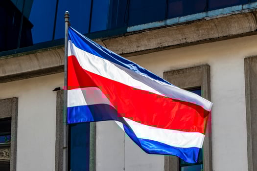Flag of Costa Rica old buildings behind Costa Rican flag. photo