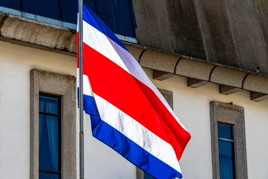 Flag of Costa Rica old buildings behind Costa Rican flag. photo