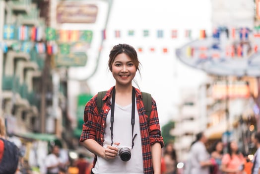 Traveler backpacker asian woman travel in Khao San road at Bangkok, Thailand. Happy young female spending holiday trip at amazing landmark and enjoy her journey in traditional city. photo