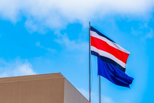 Flag of Costa Rica old buildings behind Costa Rican flag. photo