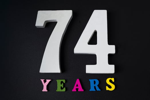 Letters and numbers seventy-four years on a black background. photo
