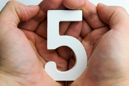 Hand holding number five. photo