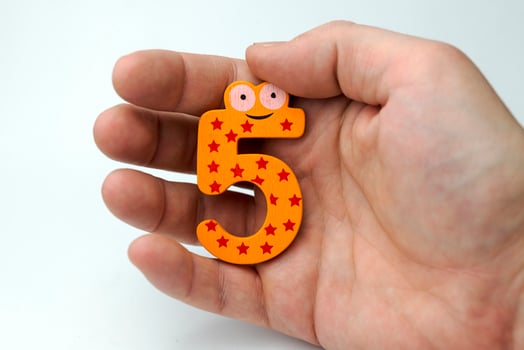 Hand holding number five. photo