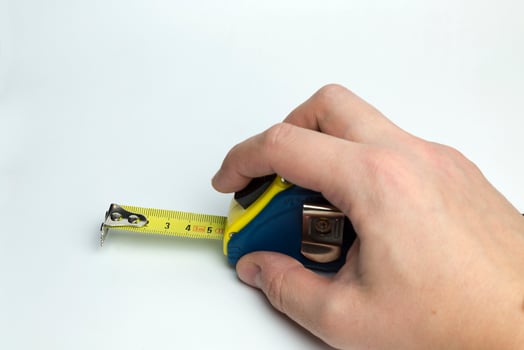 Hand on a white background holding a tape measure. photo