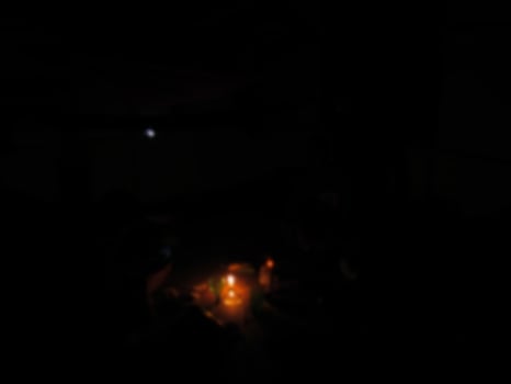 defocused on a burning candle illuminates the room at night photo