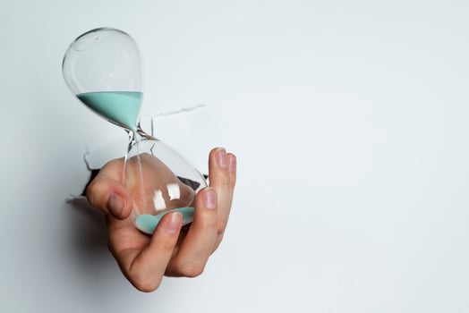 Female hand holding hourglass on white background. photo