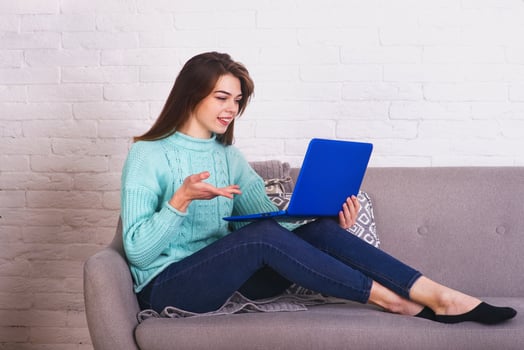 Beautiful girl is a blogger. She spends time at an online laptop conference photo