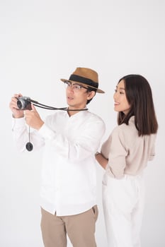 Asian couple tourists are enjoying  on white background photo