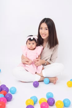 Asian mother and adorable baby girl are  happy on white background photo
