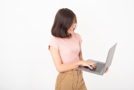 Cute Asian teen woman is working with computer on white background photo
