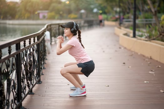 Beautiful woman is listening music and exercise  in the park photo