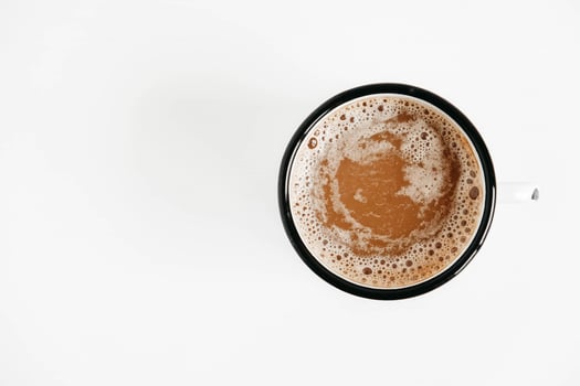 Metal mug with hot coffee on a white wooden background. Top view. Copy, empty space for text photo