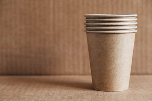 Disposable paper cups on kraft paper background photo