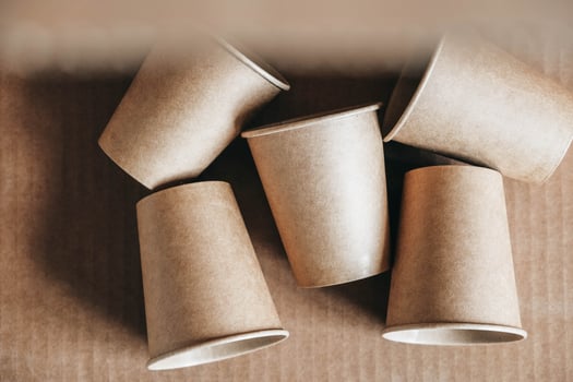 Disposable paper cups on kraft paper background photo
