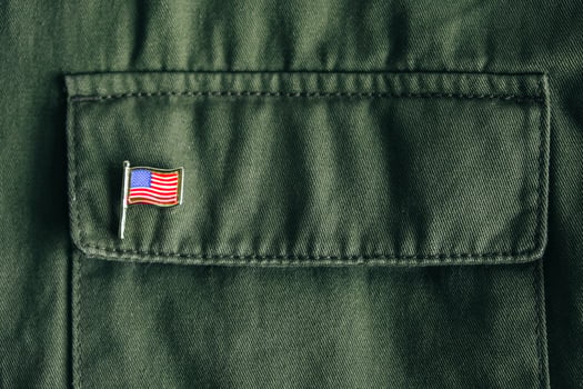 USA flag pin badge on green jacket pocket photo