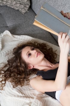 Close up of lying woman reading book relaxing at home photo