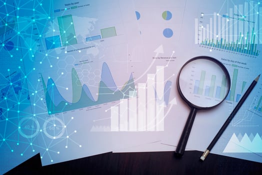 Magnifying glass and documents with analytics data lying on table photo