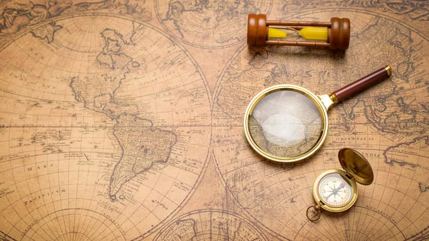 Old compass , magnifying glass and sand clock  on vintage map photo