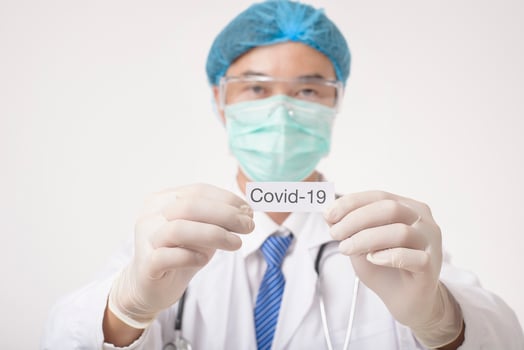 Doctor is holding Covid-19 card on white background photo