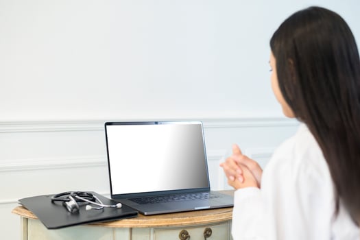 Female doctor making video call on laptop mock up screen with patient photo