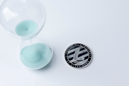 Silver bitcoin and hourglass on a white background. photo