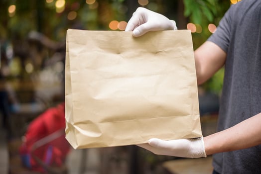 An Asian delivery man is wearing face mask, holding grocery bag , Safety home delivery concept photo