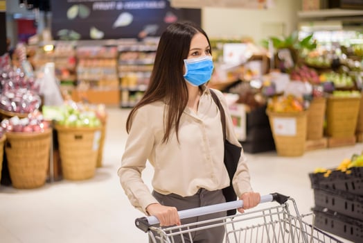 woman is shopping in supermarket with face mask photo