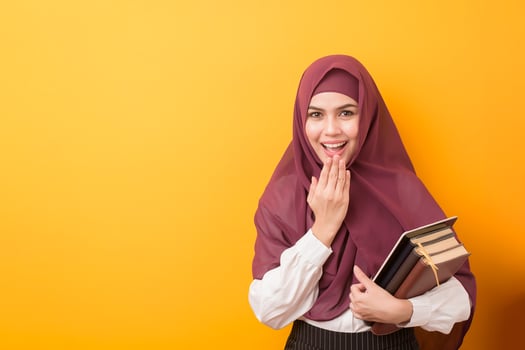 Beautiful University student with hijab portrait on yellow background photo