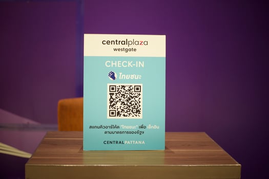 people hand is holding smartphone with Thaichana campaign of Thailand for COVID-19 prevention in shopping center photo